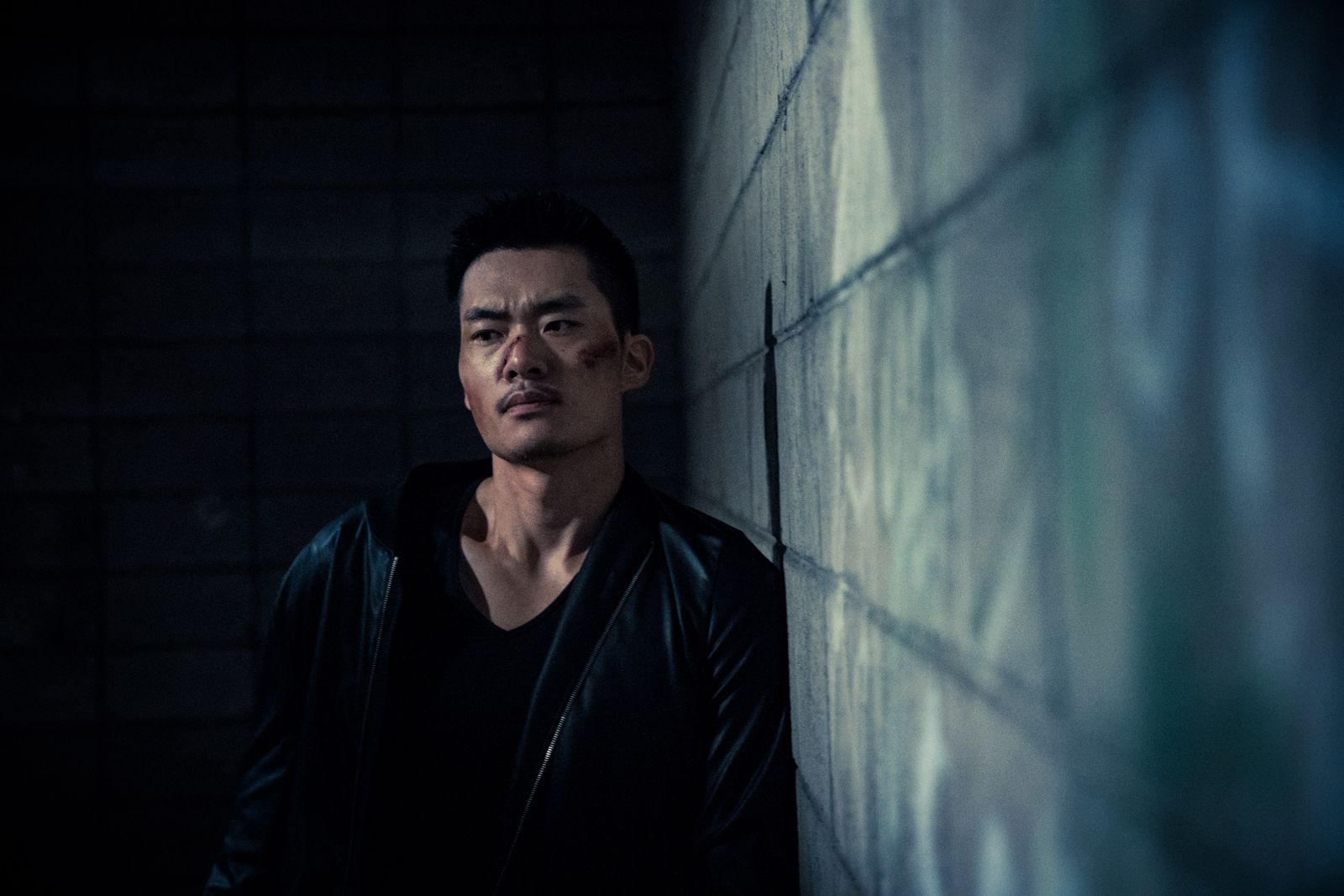 Kuang Feng leaning against a concrete wall